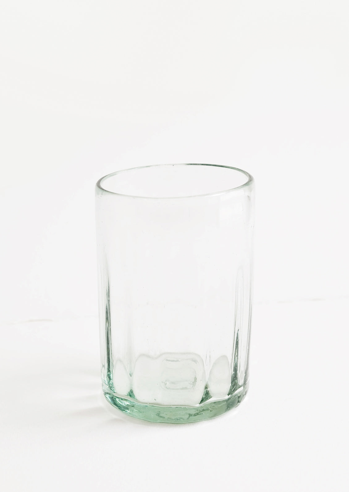 A horizontally ribbed tumblers in thick green hued glass.