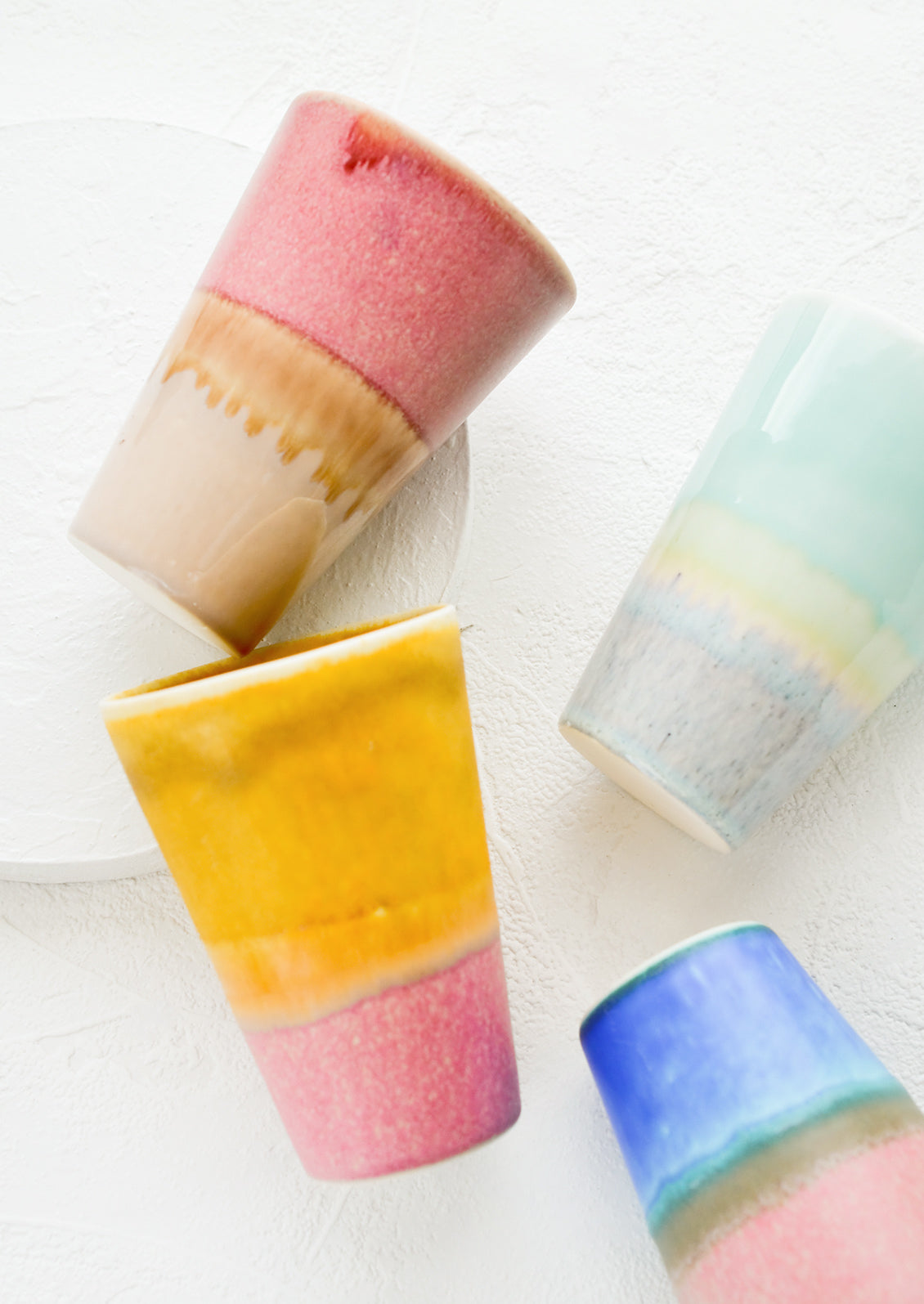 An assortment of colorful ceramic tumblers.
