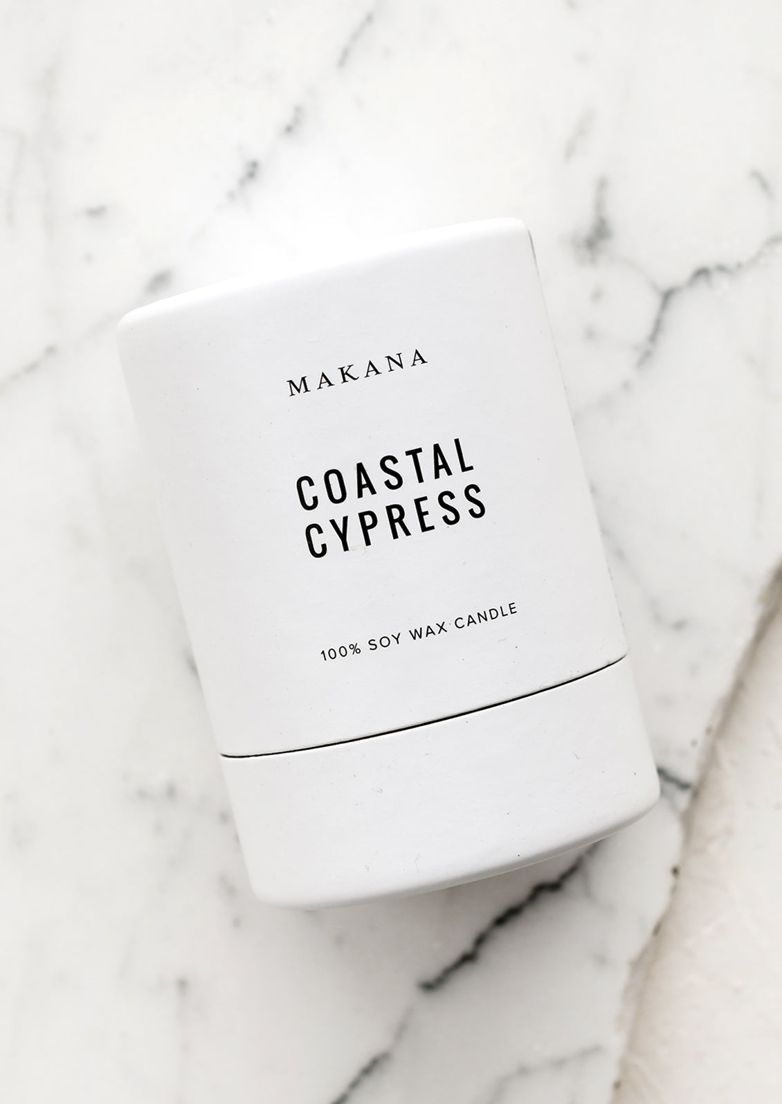 A votive scented candle in cylinder packaging.