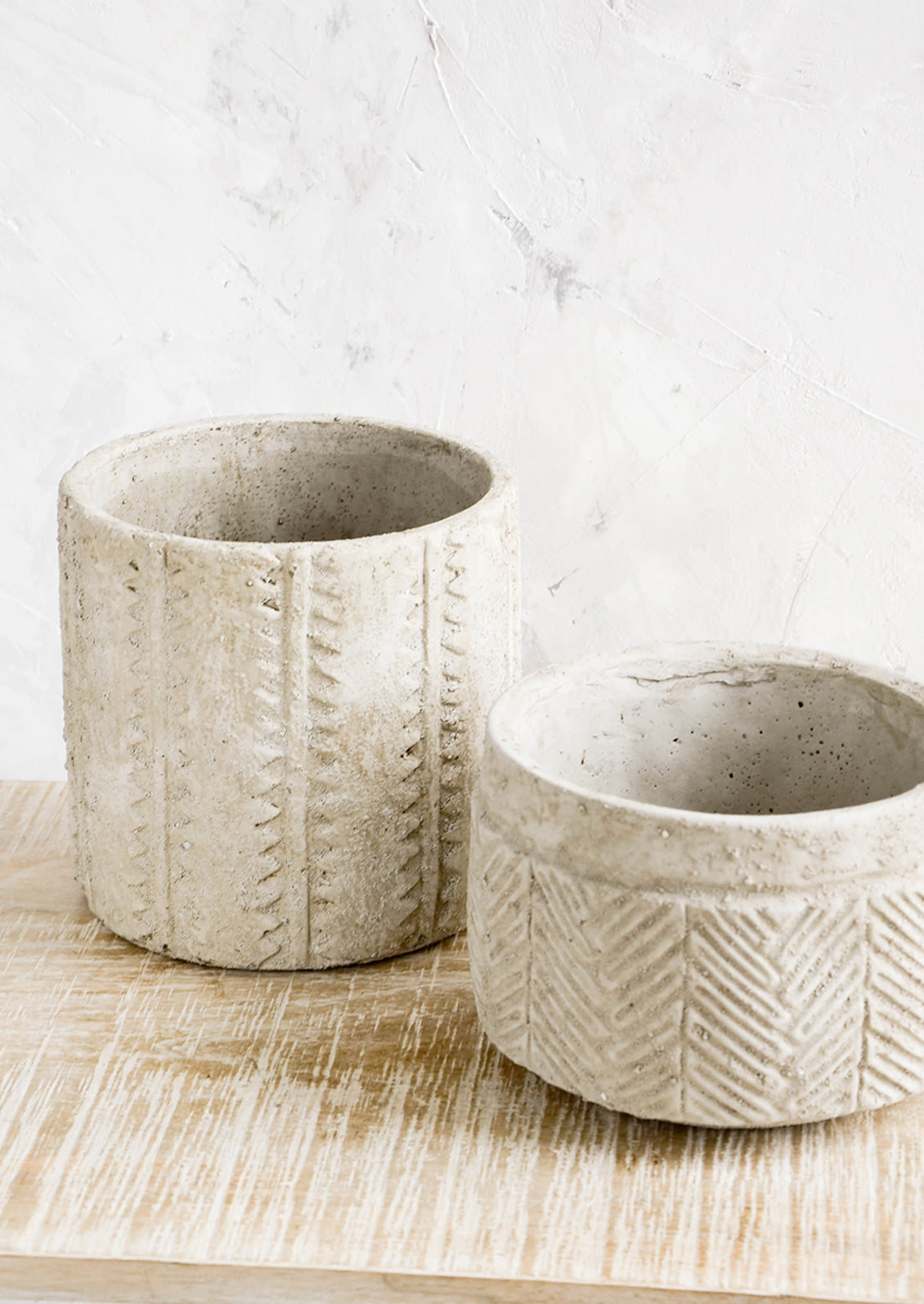 Distressed planters in concrete-like texture, in two different sizes with varying patterns