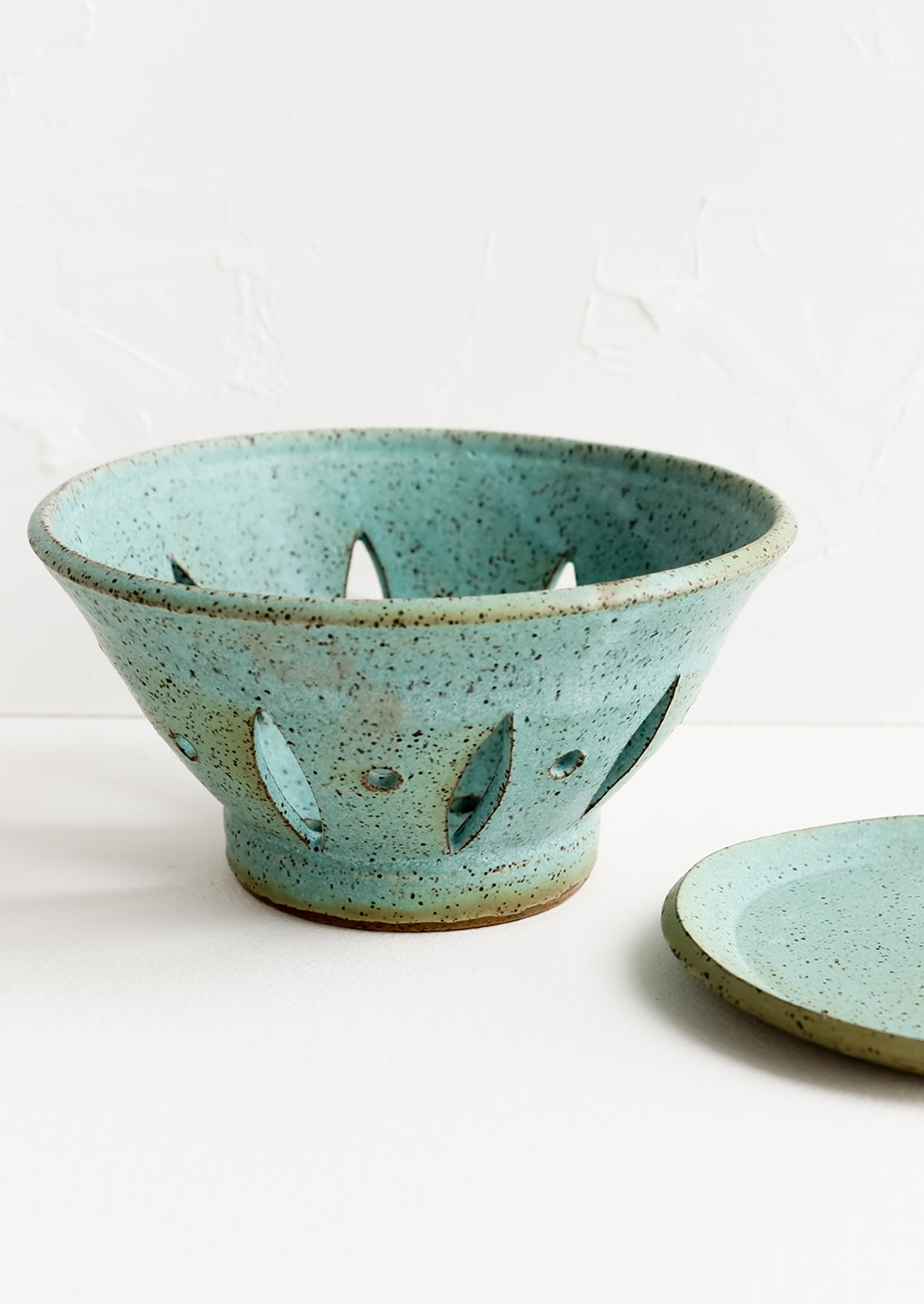 A ceramic berry bowl with plate in turquoise.