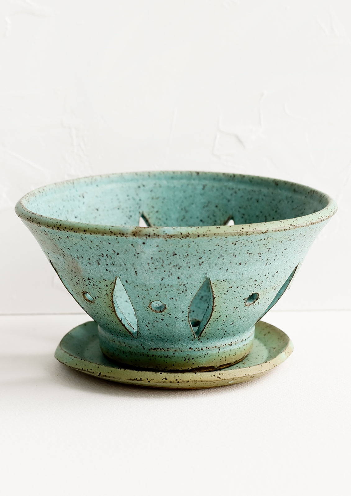 A ceramic berry bowl with plate in turquoise.