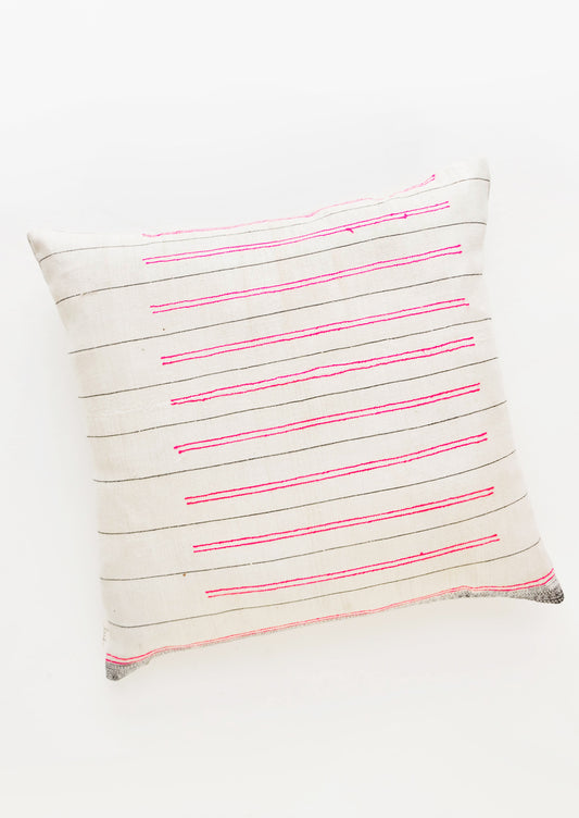 Square throw pillow in white fabric with thin black lines and striped hot pink embroidery