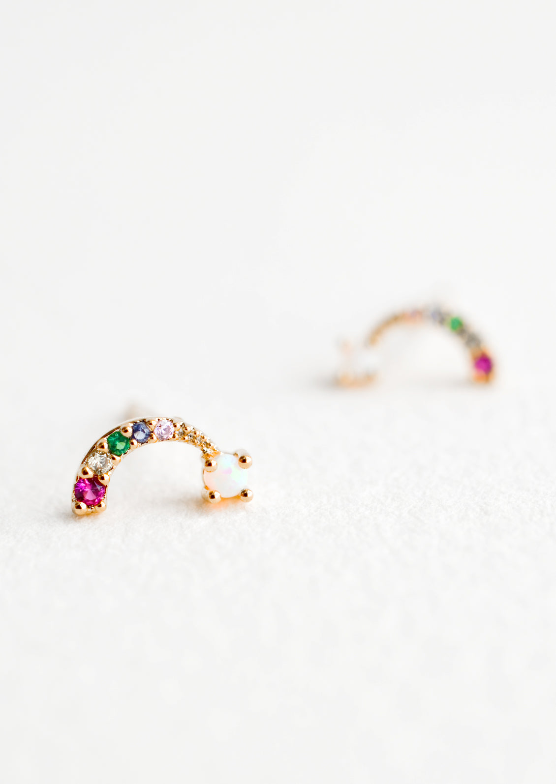 Rainbow shaped stud earrings with colored crystals and opal "cloud" at end