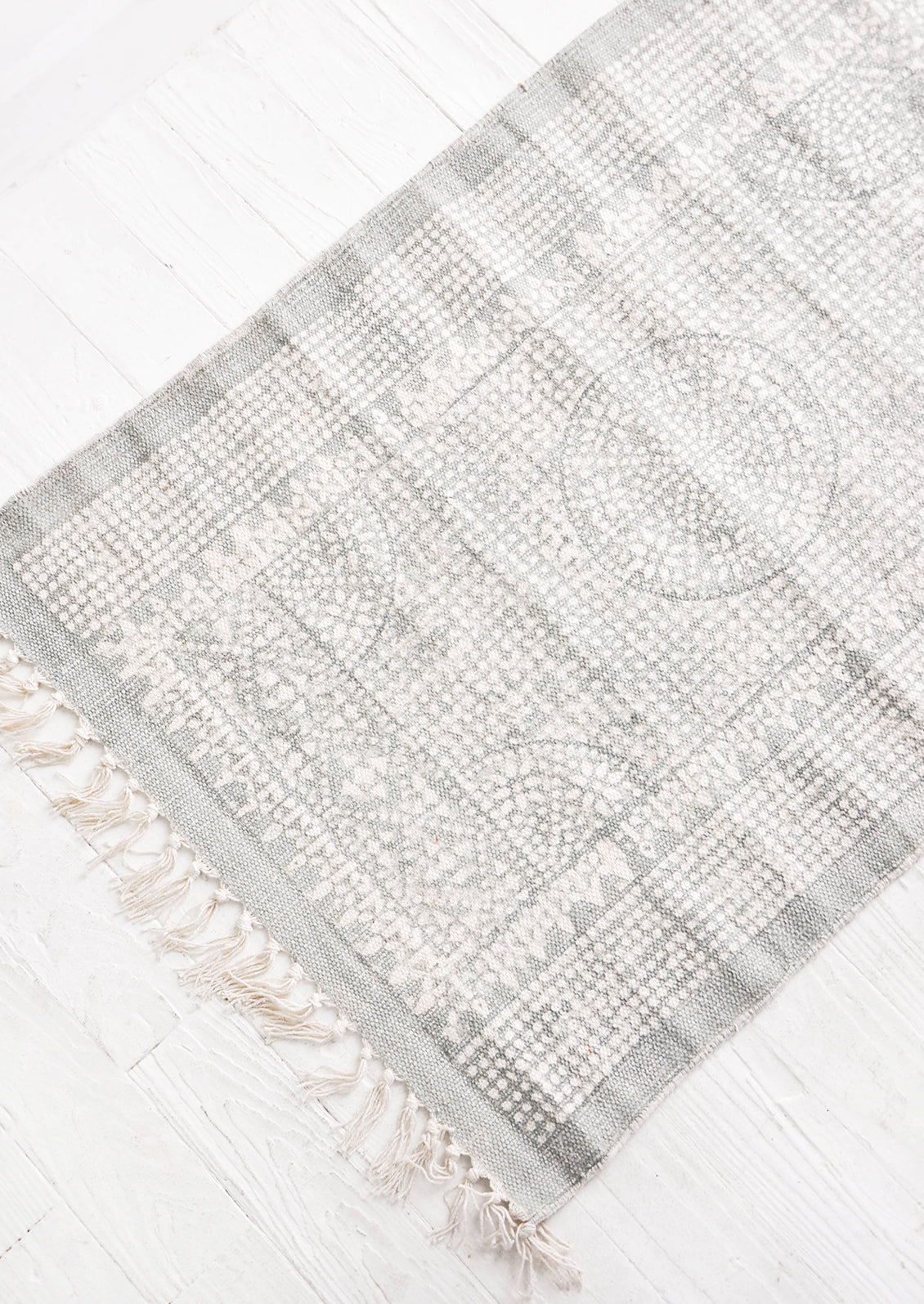 Flatweave rug with contrasting oriental pattern and fringe trimmed edges on two sides