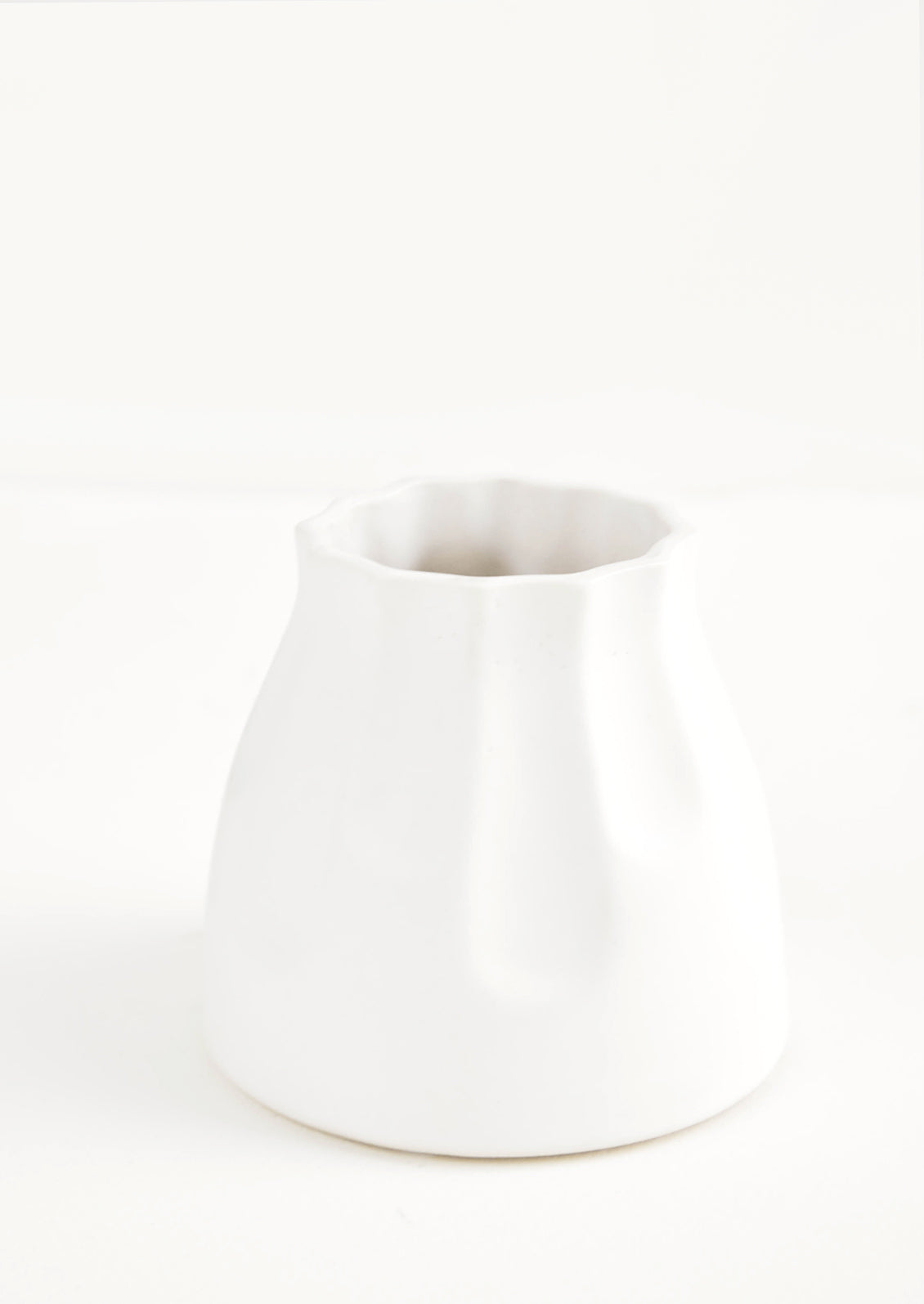 Small and round mini ceramic vase in white with fluting detailing along top