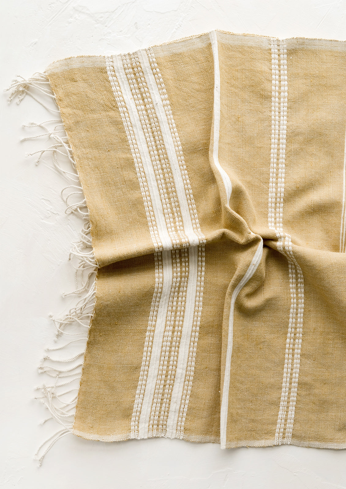 A cotton hand towel in brown with woven natural stripes.