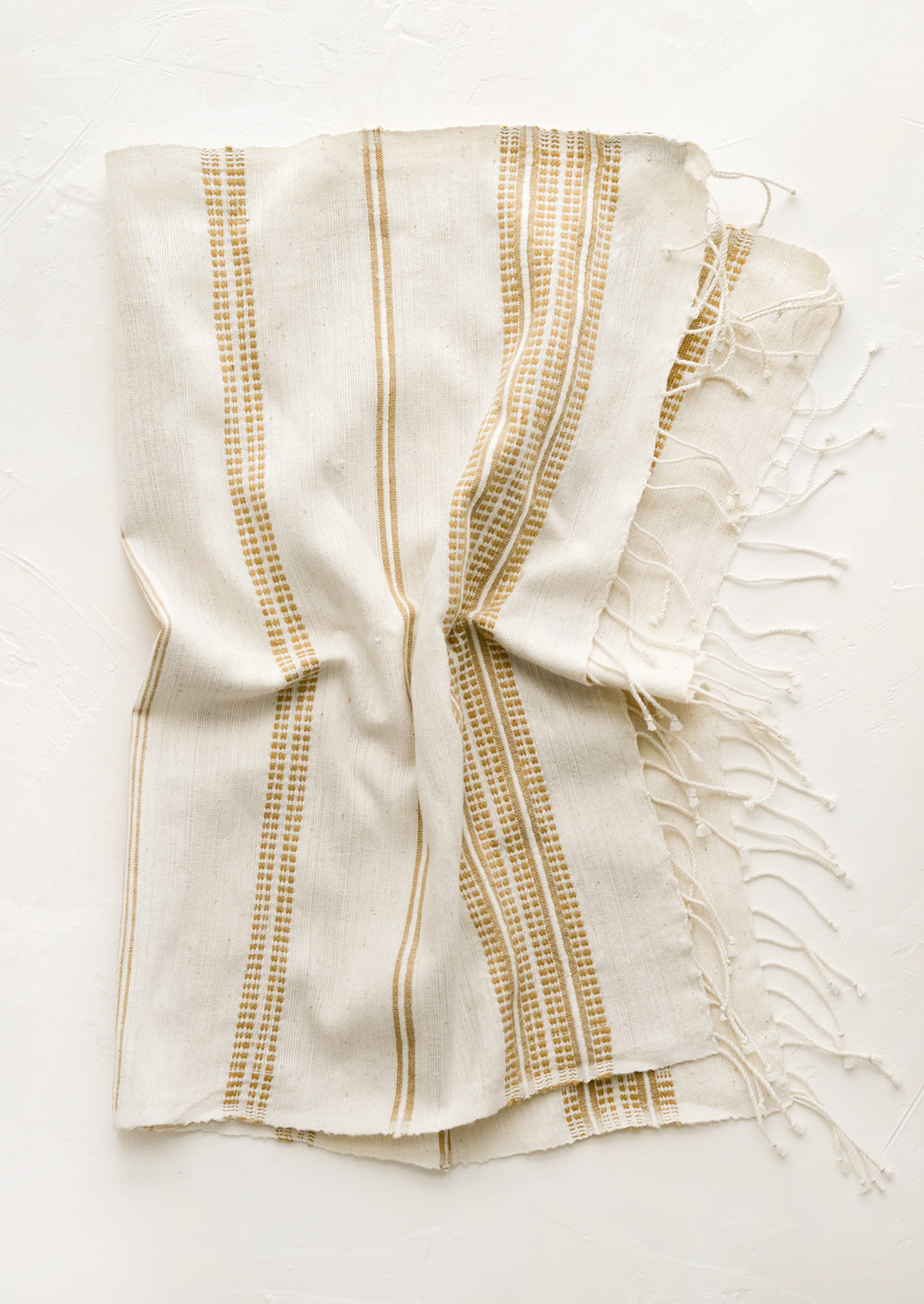 A cotton hand towel in natural with woven brown stripes.