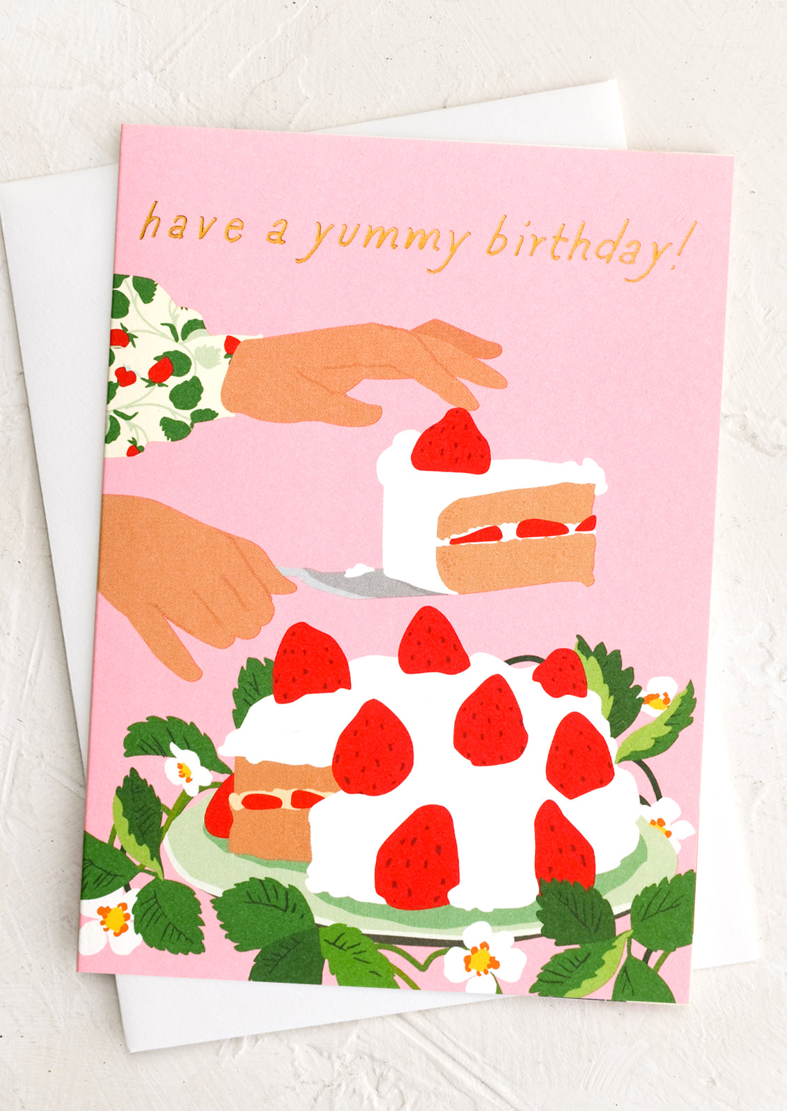A pink greeting card with illustration of a woman serving a strawberry cake, text at top reads "Have a yummy birthday!".