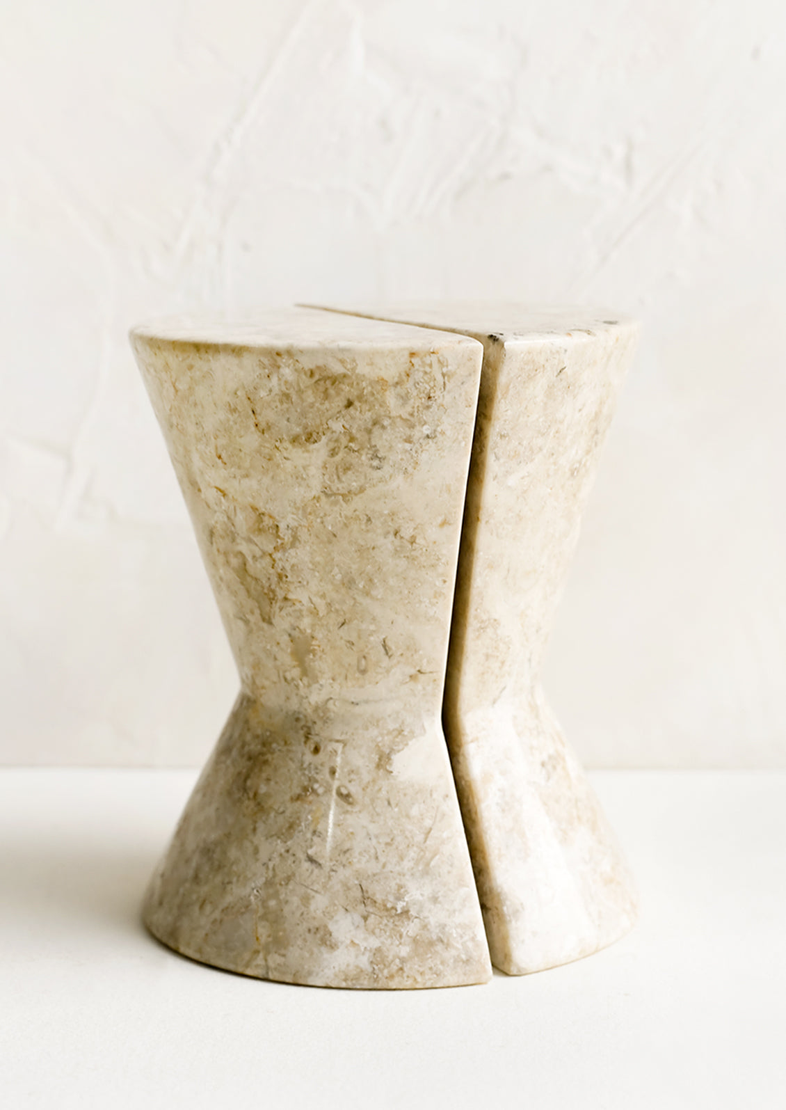 A pair of hourglass shaped bookends in tan marble.