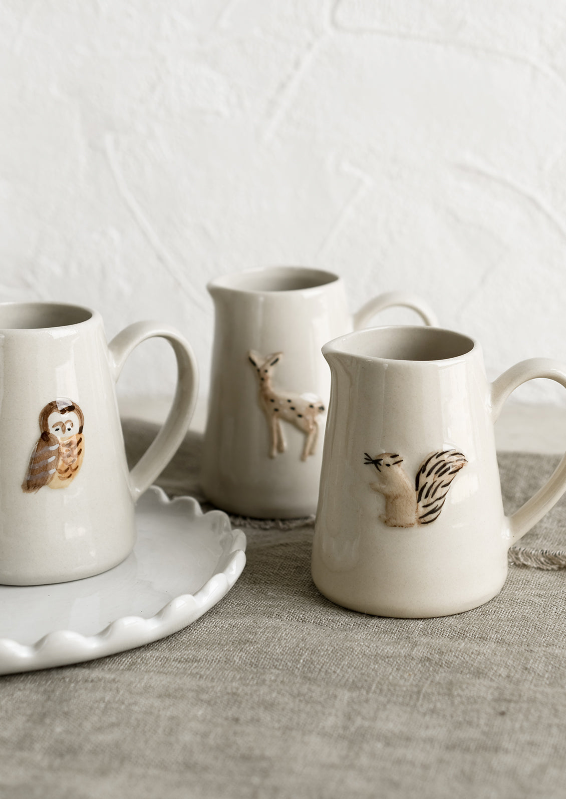 Ceramic creamer pitchers with assorted woodland creature motifs.
